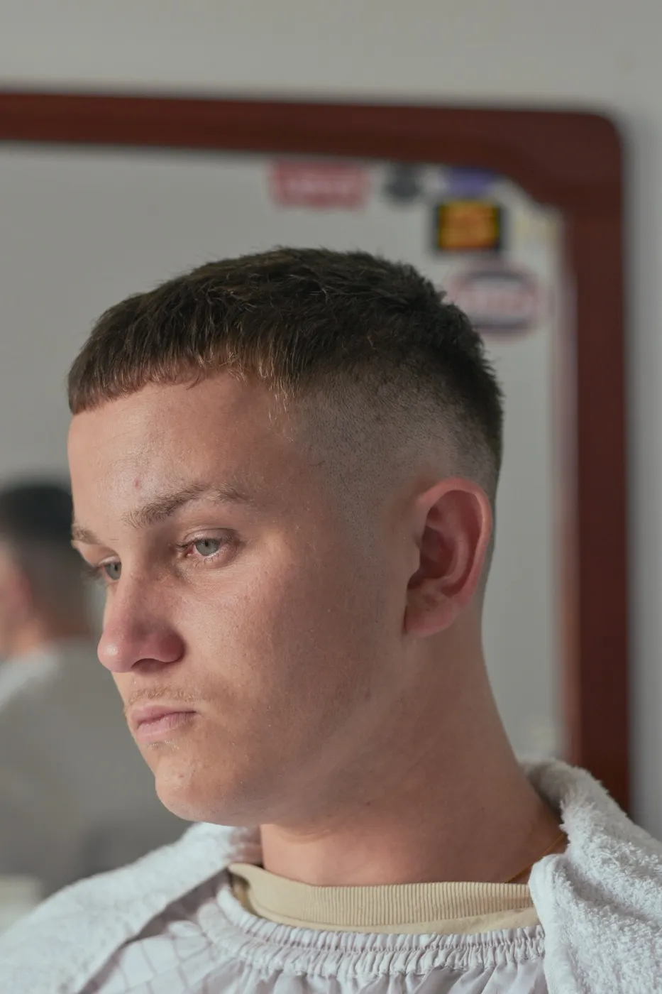 Corte bem curto com degradê alto na lateral, visto de perfil